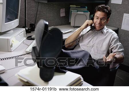 Businessman talking on a landline telephone on the desk View Large Photo Image Stock Image - Businessman talking on a landline telephone on the desk. Fotosearch