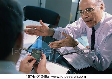 Stock Image - Businessmen discussing in an office. Fotosearch