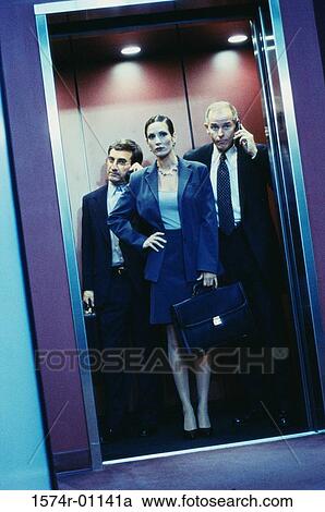 Stock Image - Businesswoman and two businessmen in an elevator. Fotosearch
