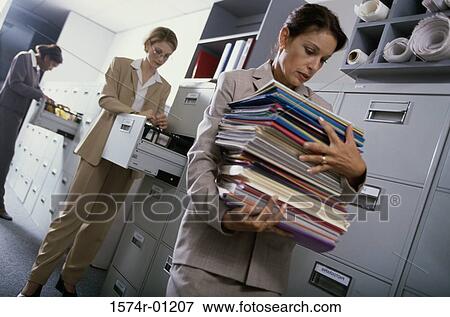 Stock Photo - Businesswoman carrying a stack of files. Fotosearch