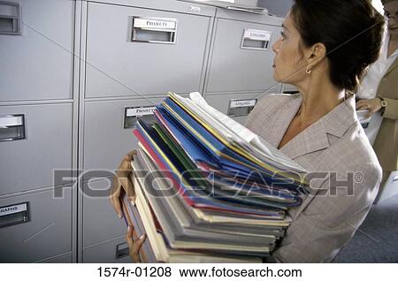 Stock Photo - Businesswoman carrying a stack of files. Fotosearch