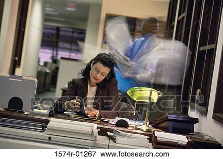 Businesswoman talking on a landline telephone at her desk View Large Photo Image Stock Photo - Businesswoman talking on a landline telephone at her desk. Fotosearch