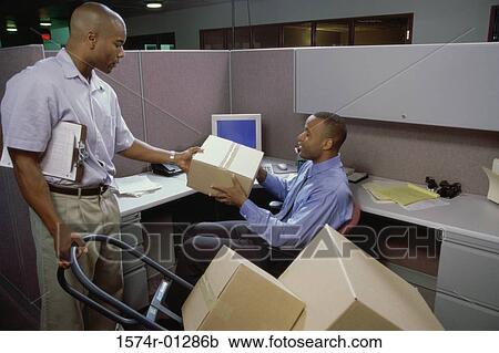 Delivery man giving a parcel to a businessman View Large Photo Image Stock Image - Delivery man giving a parcel to a businessman. Fotosearch