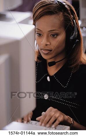 Stock Image - Female customer service representative wearing a headset. Fotosearch