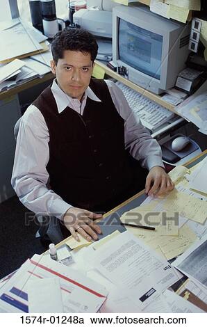 High angle view of a businessman sitting at his desk View Large Photo Image Stock Image - High angle view of a businessman sitting at his desk. Fotosearch