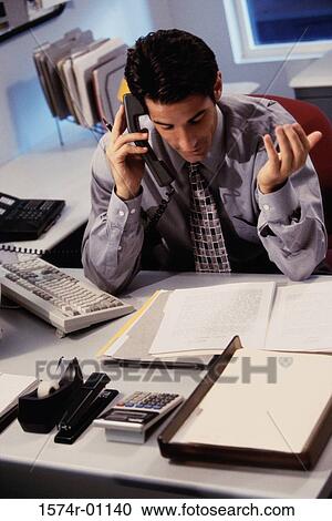 High angle view of a young businessman using a landline telephone on his desk View Large Photo Image Stock Image - High angle view of a young businessman using a landline telephone on his desk. Fotosearch