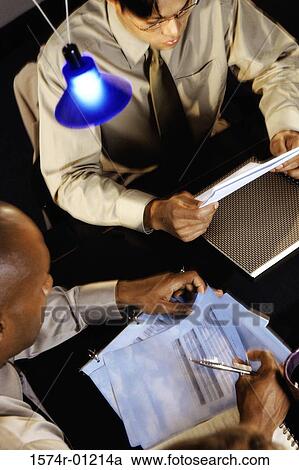 High angle view of two businessmen looking through papers View Large Photo Image Stock Image - High angle view of two businessmen looking through papers. Fotosearch