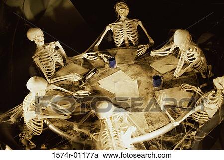 Stock Image - Human skeletons covered in cobwebs at a meeting. Fotosearch