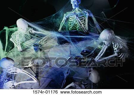 Stock Photograph - Human skeletons covered in cobwebs at a meeting. Fotosearch