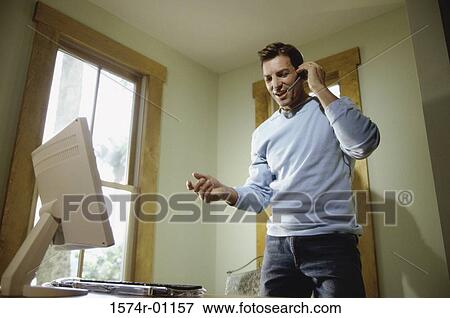 Low angle view of a businessman talking on a mobile phone View Large Photo Image Stock Photo - Low angle view of a businessman talking on a mobile phone. Fotosearch