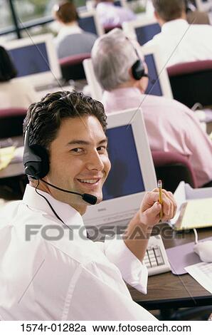 Portrait of a male customer service representative sitting in front of a computer monitor View Large Photo Image Stock Image - Portrait of a male customer service representative sitting in front of a computer monitor. Fotosearch