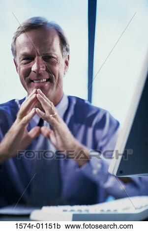 Portrait of businessman sitting at his desk View Large Photo Image Stock Image - Portrait of businessman sitting at his desk. Fotosearch