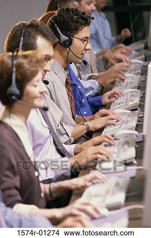 Picture - Row of customer service representatives sitting in front of computer monitors. Fotosearch