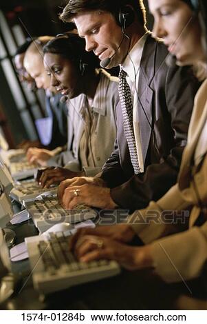 Row of customer service representatives sitting in front of computer monitors View Large Photo Image Stock Image - Row of customer service representatives sitting in front of computer monitors. Fotosearch