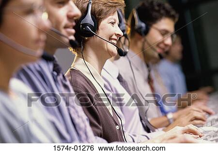 Stock Photograph - Row of customer service representatives sitting in front of computer monitors. Fotosearch
