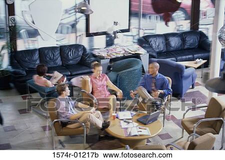 Stock Image - Three business executives discussing in an office. Fotosearch