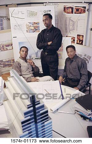 Stock Image - Three businessmen together in an office. Fotosearch