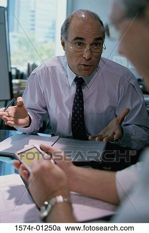 Stock Image - Two businessmen in a meeting. Fotosearch