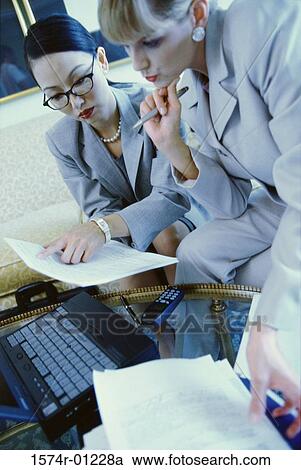 Two businesswomen reading documents View Large Photo Image Stock Image - Two businesswomen reading documents. Fotosearch