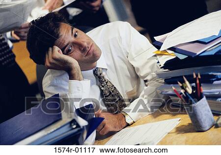 Young businessman resting his head on his fist View Large Photo Image Stock Photo - Young businessman resting his head on his fist. Fotosearch
