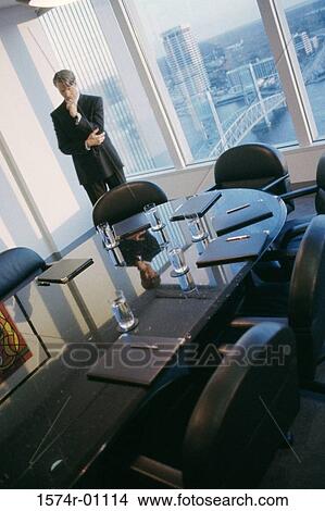 Picture - Young businessman standing alone in a conference room. Fotosearch