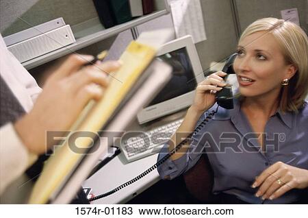 Stock Image - Young businesswomen talking on the landline telephone. Fotosearch