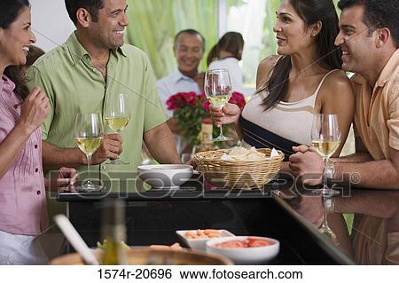 Close-up of a mature couple and a mid adult couple looking at each other and smiling View Large Photo Image Stock Photograph - Close-up of a mature couple and a mid adult couple looking at each other and smiling. Fotosearch