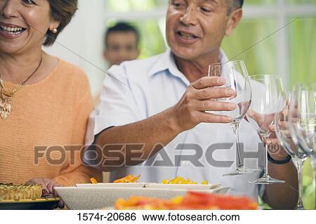 Close-up of a mature woman smiling with a mature man holding two glasses of wine View Large Photo Image Stock Photograph - Close-up of a mature woman smiling with a mature man holding two glasses of wine. Fotosearch