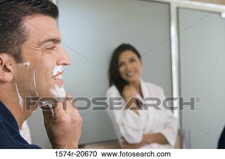 Close-up of a mid adult man shaving and a mid adult woman looking at him View Large Photo Image Stock Image - Close-up of a mid adult man shaving and a mid adult woman looking at him. Fotosearch