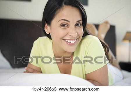 Portrait of a mature woman lying in the bed and smiling View Large Photo Image Stock Image - Portrait of a mature woman lying in the bed and smiling. Fotosearch