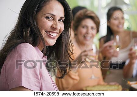 Stock Photo - Portrait of a mature woman with her friends enjoying a party. Fotosearch