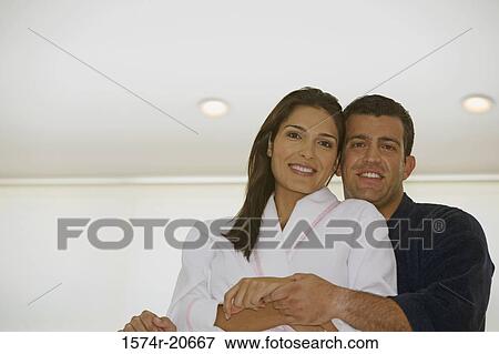 Stock Photo - Portrait of a mid adult man embracing a mid adult woman. Fotosearch