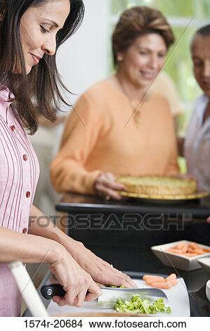 Side profile of a mature woman cutting vegetables View Large Photo Image Picture - Side profile of a mature woman cutting vegetables. Fotosearch