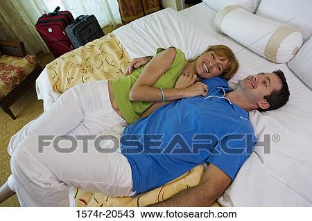 High angle view of a young couple lying on the bed and smiling View Large Photo Image Stock Image - High angle view of a young couple lying on the bed and smiling. Fotosearch