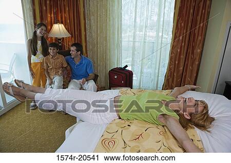 High angle view of a young couple with their son and daughter in a hotel room View Large Photo Image Stock Image - High angle view of a young couple with their son and daughter in a hotel room. Fotosearch
