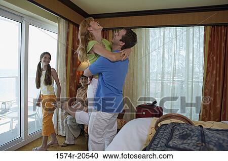 Side profile of a young couple with their son and daughter in a hotel room View Large Photo Image Stock Image - Side profile of a young couple with their son and daughter in a hotel room. Fotosearch