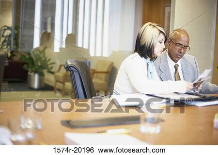 Businessman and a businesswoman talking in an office View Large Photo Image Stock Photograph - Businessman and a businesswoman talking in an office. Fotosearch