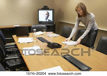 Businesswoman placing a ring binder file in a conference room View Large Photo Image Picture - Businesswoman placing a ring binder file in a conference room. Fotosearch