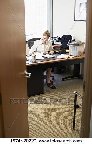 Businesswoman sitting in a chair in an office View Large Photo Image Stock Image - Businesswoman sitting in a chair in an office. Fotosearch
