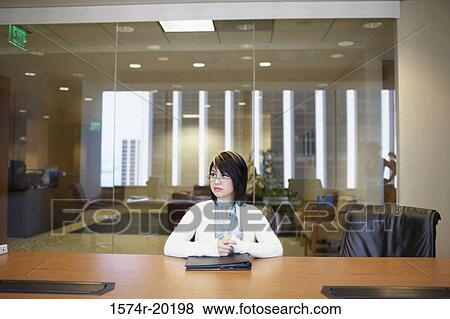 Businesswoman sitting in an office View Large Photo Image Stock Photo - Businesswoman sitting in an office. Fotosearch