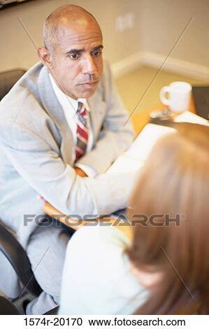 High angle view of a businessman and a businesswoman talking in an office View Large Photo Image Stock Image - High angle view of a businessman and a businesswoman talking in an office. Fotosearch