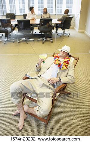 High angle view of a businessman relaxing in an office View Large Photo Image Stock Image - High angle view of a businessman relaxing in an office. Fotosearch