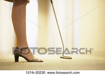 Low section view of a businesswoman standing with a golf club View Large Photo Image Stock Image - Low section view of a businesswoman standing with a golf club. Fotosearch