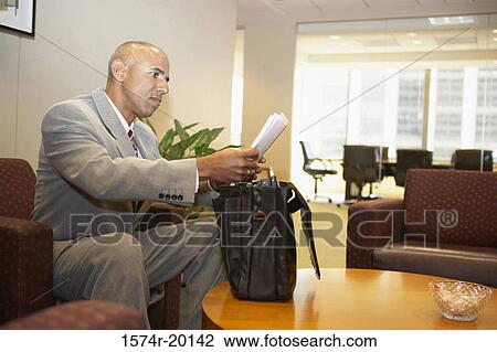Side profile of a businessman reading documents View Large Photo Image Stock Image - Side profile of a businessman reading documents. Fotosearch