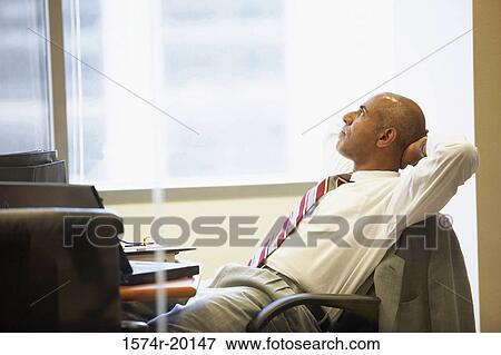 Side profile of a businessman sitting in an office View Large Photo Image Stock Photo - Side profile of a businessman sitting in an office. Fotosearch
