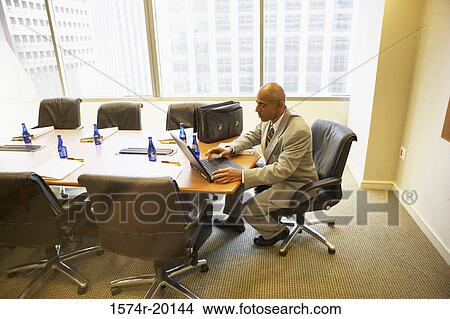 Picture - Side profile of a businessman using a laptop. Fotosearch