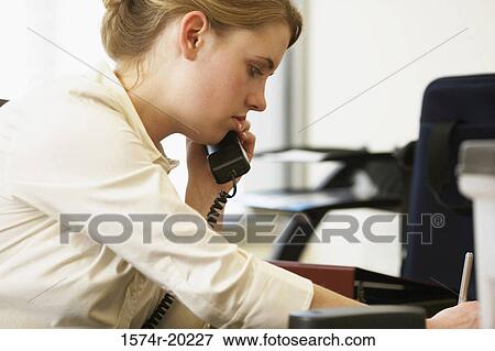 Side profile of a businesswoman using a telephone in an office View Large Photo Image Stock Photo - Side profile of a businesswoman using a telephone in an office. Fotosearch