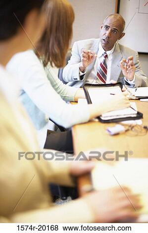 Stock Photo - Two businesswomen and a businessman talking in an conference room. Fotosearch