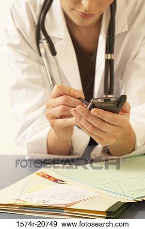 Close-up of a female doctor using a PDA View Large Photo Image Stock Photo - Close-up of a female doctor using a PDA. Fotosearch