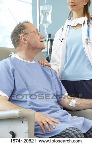Close-up of a male patient sitting in an armchair and a female doctor standing beside him View Large Photo Image Stock Image - Close-up of a male patient sitting in an armchair and a female doctor standing beside him. Fotosearch